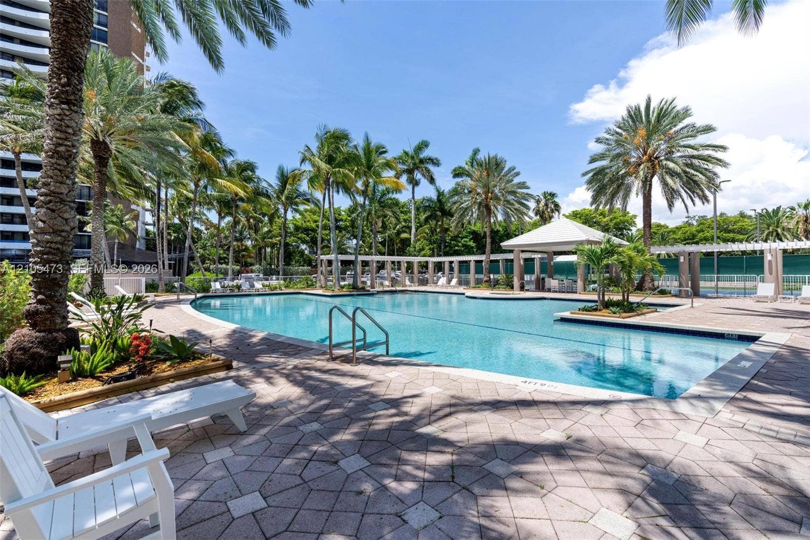 770 NE 69th Street, #6F, Miami, FL 33138 Swimming pool featuring a paved deck, built-in covered pavilion, pergola structures, and mature palm landscaping