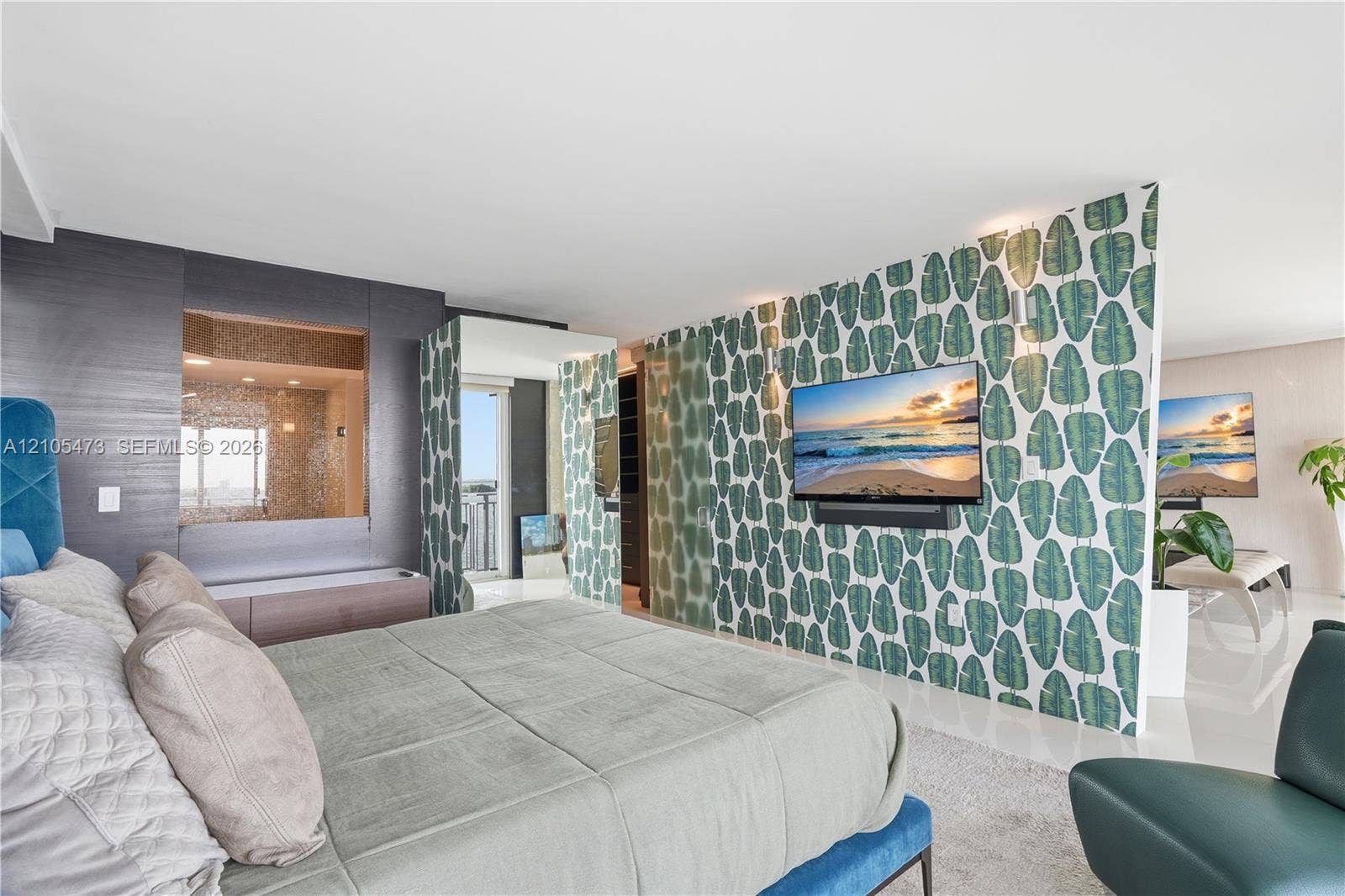 770 NE 69th Street, #6F, Miami, FL 33138 Integrated wall-mounted television, textured accent wall with built-in niche, patterned room divider, tiled shower enclosure, and light-colored flooring