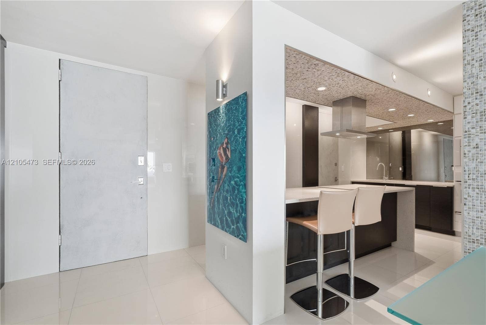 770 NE 69th Street, #6F, Miami, FL 33138 Kitchen featuring a stainless steel range hood, recessed lighting, dark cabinetry, a breakfast bar, and tile flooring