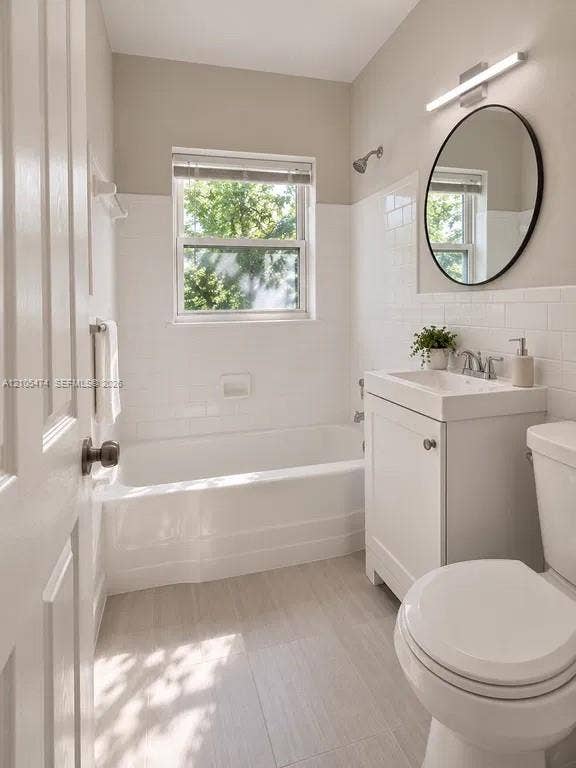 Bathroom featuring a white subway tile surround, neutral wall paint, and light-toned tile flooring
