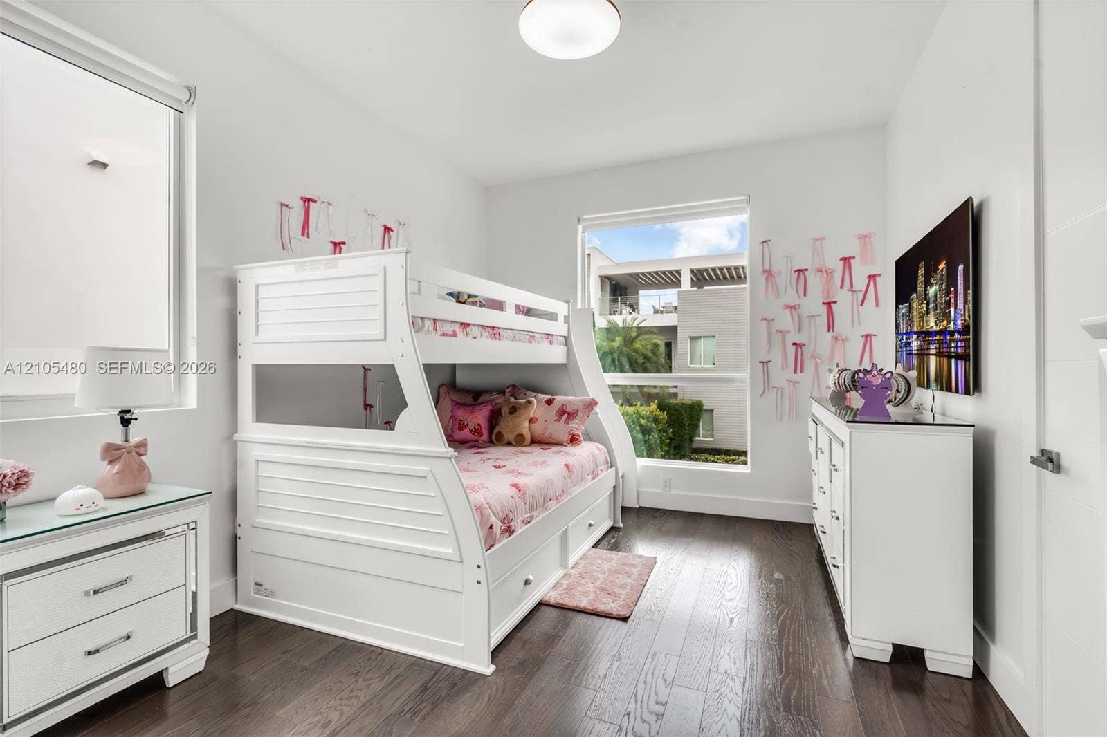 Rich wood-finish flooring, bright white walls, and recessed lighting