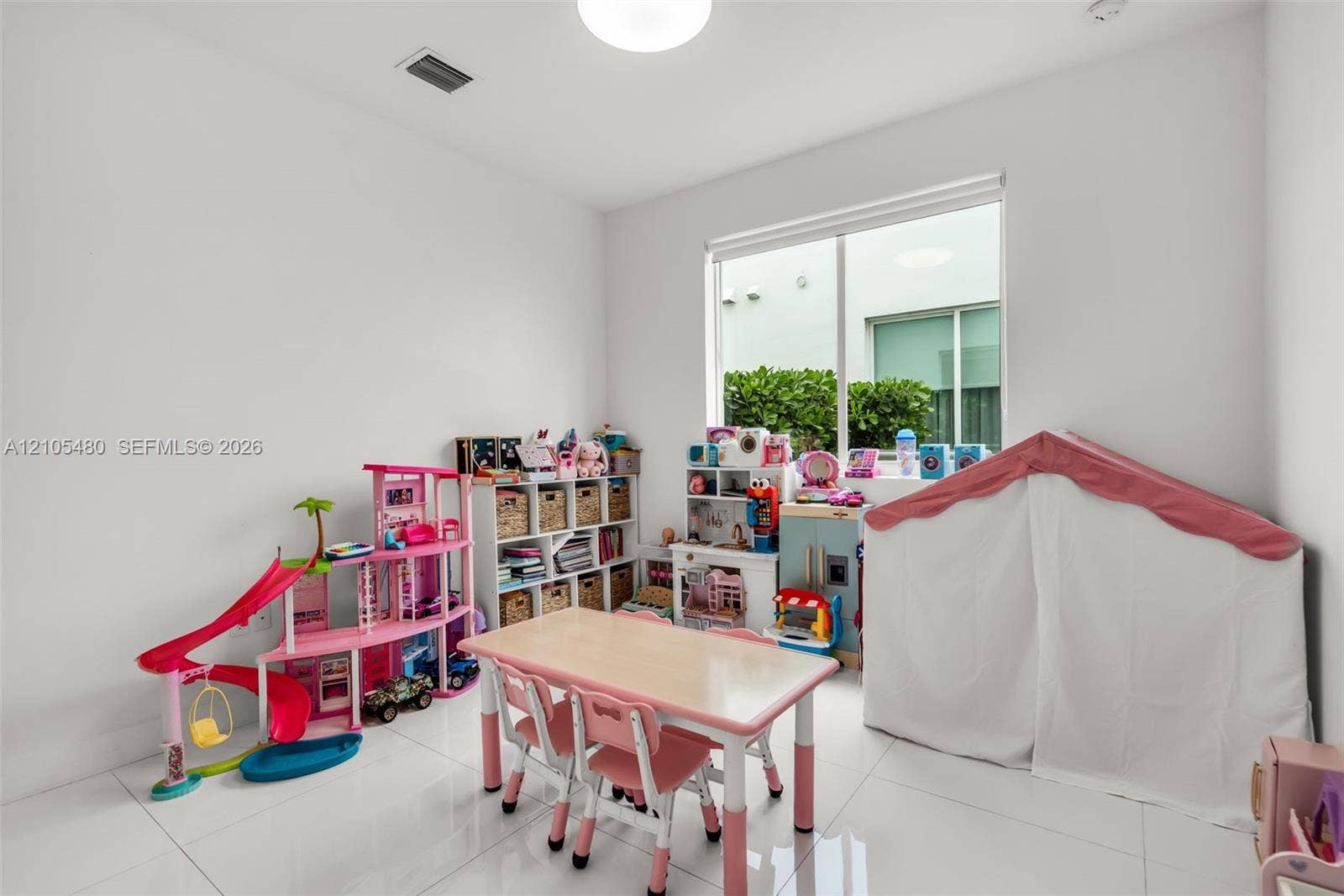 White-tiled flooring with smooth white walls, recessed ceiling lighting, and a large window