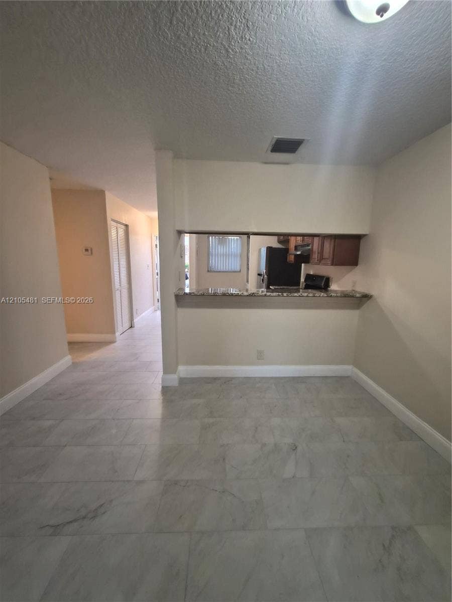 10909 Royal Palm Boulevard, #10909, Coral Springs, Coral Springs, FL 33065 Porcelain tile flooring, neutral wall tones, pass-through window, wood cabinetry, and recessed lighting