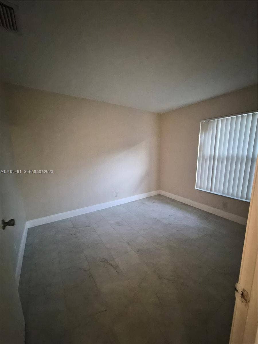10909 Royal Palm Boulevard, #10909, Coral Springs, Coral Springs, FL 33065 Tile flooring, neutral wall tones, window with horizontal blinds, and white trim molding