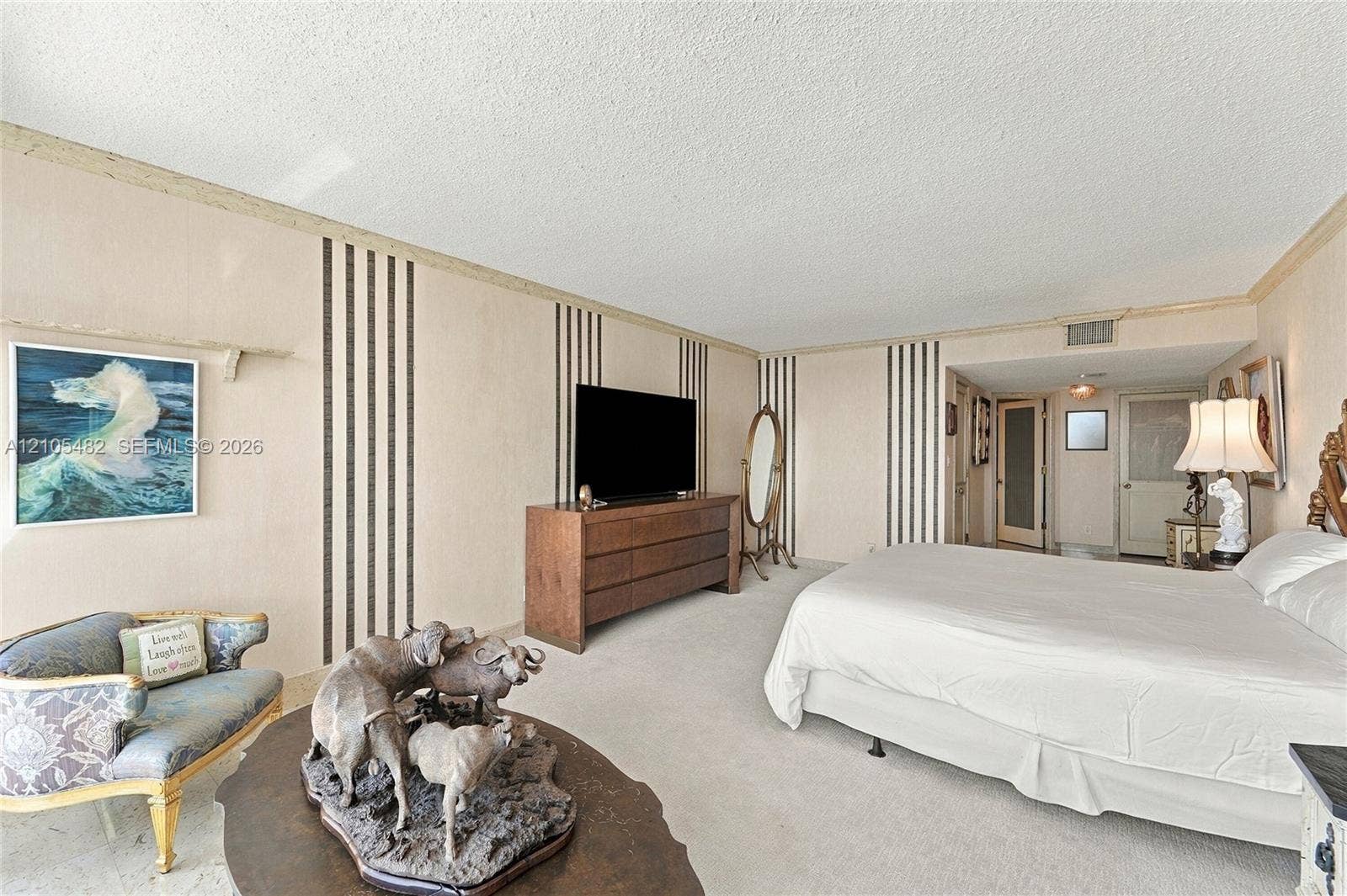 2100 S Ocean Lane, #808, Fort Lauderdale, FL 33316 Neutral-toned room featuring vertical paneled wall accents, crown molding, and wall-to-wall carpeting