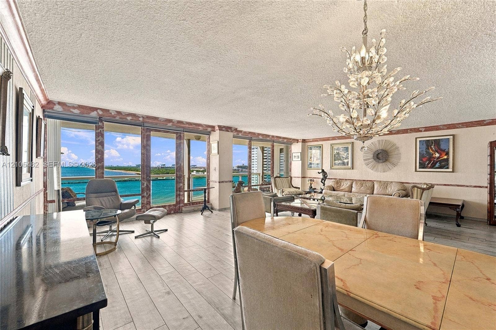 2100 S Ocean Lane, #808, Fort Lauderdale, FL 33316 Open-concept living space featuring wood-finish flooring, floor-to-ceiling windows, and a decorative chandelier
