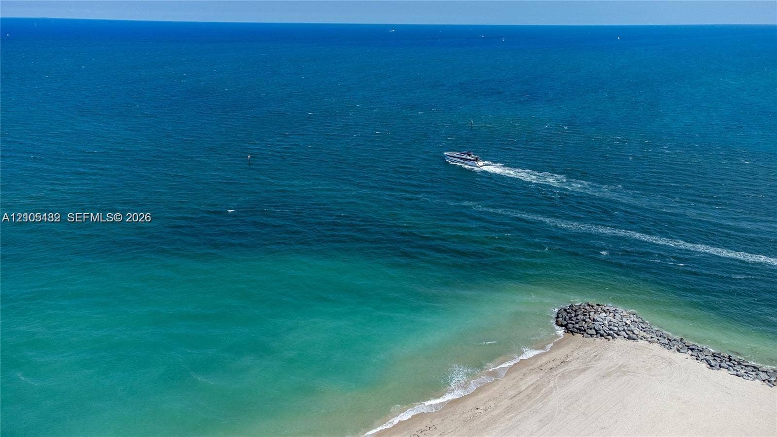 2100 S Ocean Lane, #808, Fort Lauderdale, FL 33316 Coastal property featuring direct water frontage, a sandy beach, and stone-reinforced shoreline