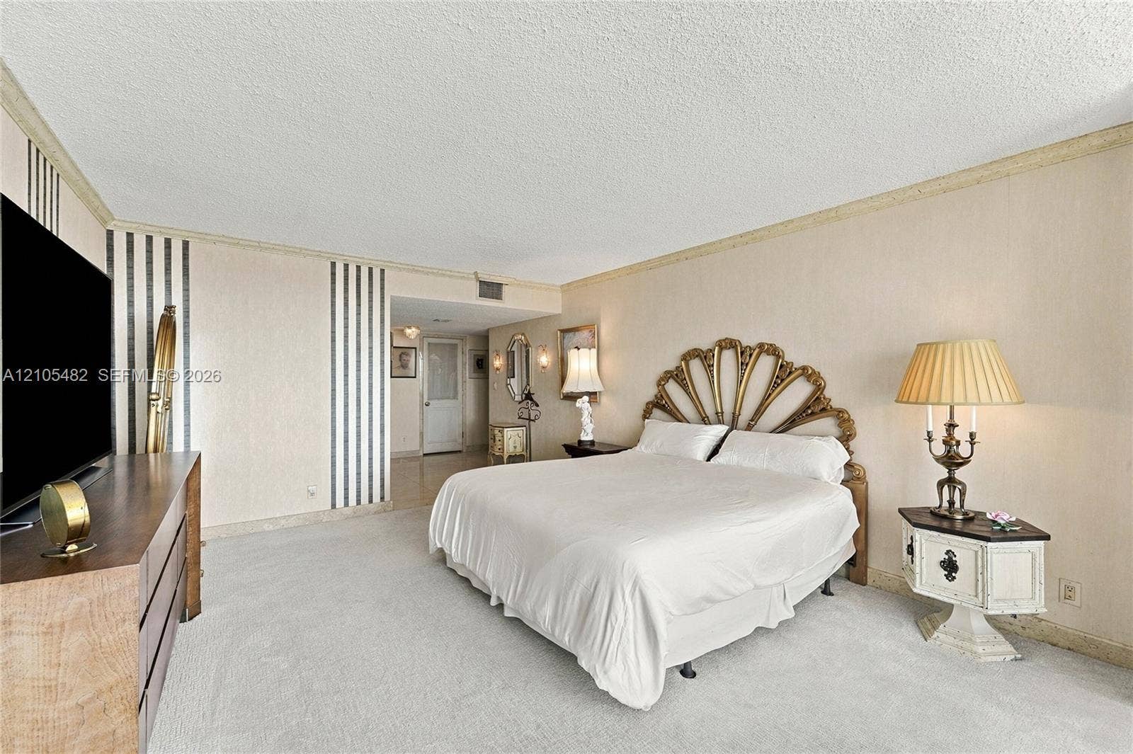 2100 S Ocean Lane, #808, Fort Lauderdale, FL 33316 Spacious room featuring vertical striped wall treatments, neutral carpeting, textured ceiling, and crown molding