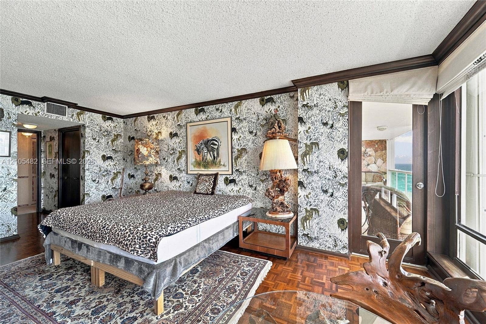 2100 S Ocean Lane, #808, Fort Lauderdale, FL 33316 Parquet wood flooring, crown molding, and glass door providing access to a balcony with exterior stonework