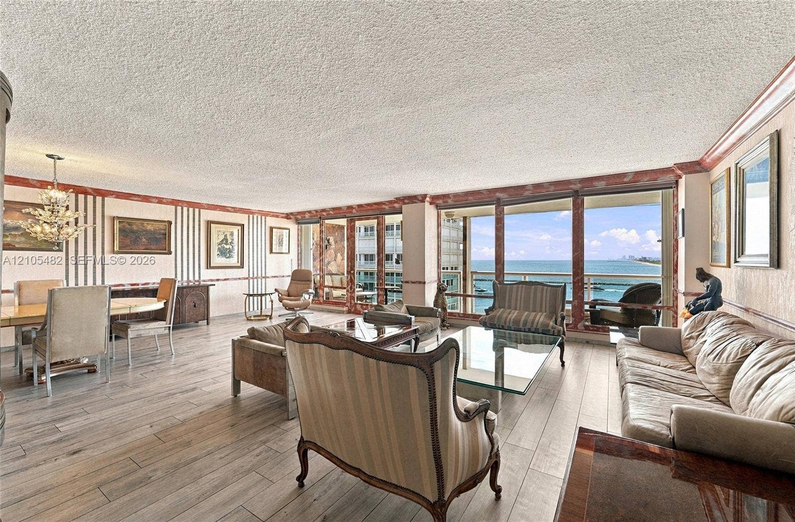 2100 S Ocean Lane, #808, Fort Lauderdale, FL 33316 Living area featuring wood-finish flooring, full-height windows, and crown molding with stone-finish accents