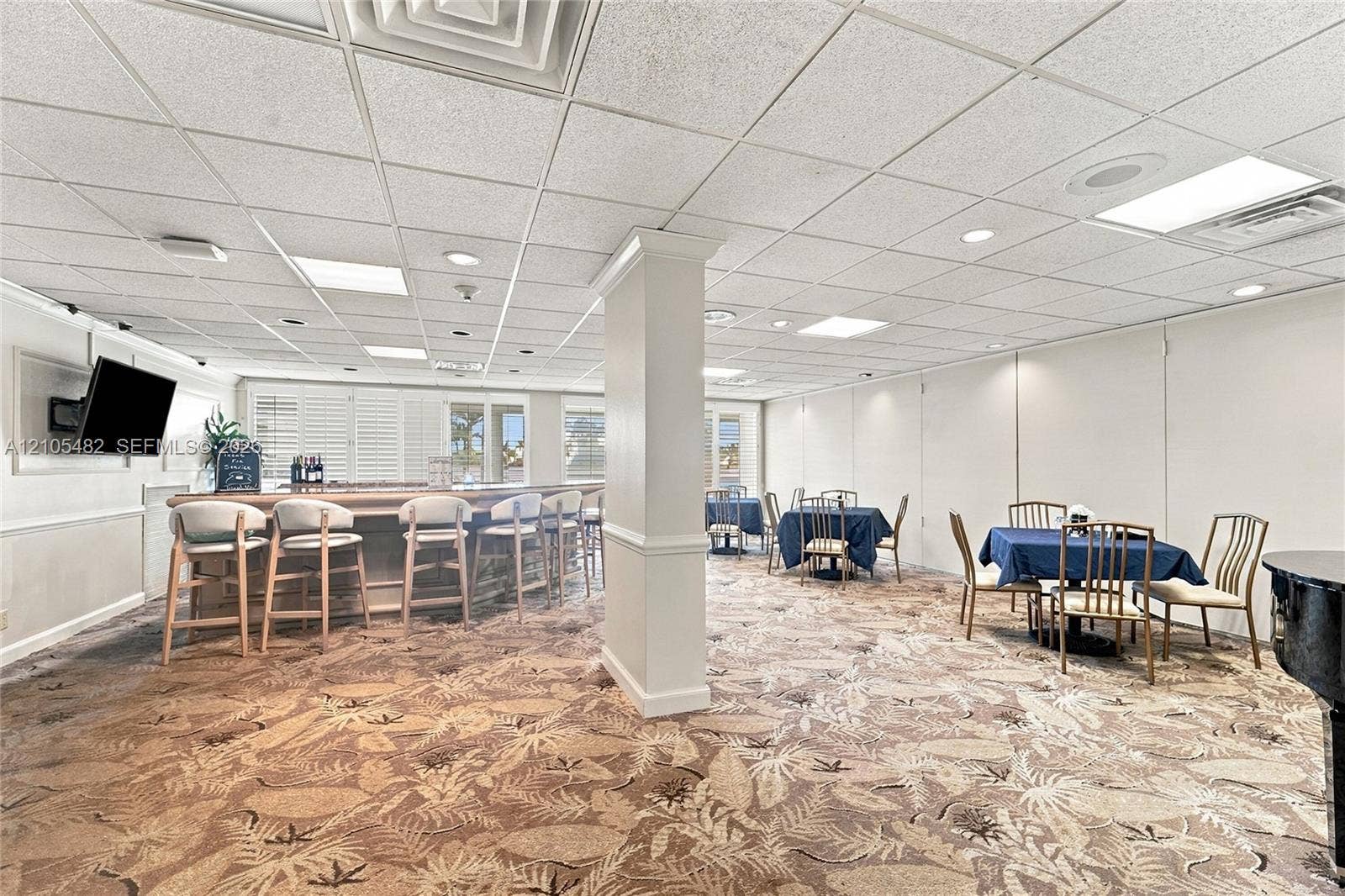 2100 S Ocean Lane, #808, Fort Lauderdale, FL 33316 Built-in bar with a countertop, drop ceiling with recessed lighting, patterned wall-to-wall carpeting, and shuttered window treatments