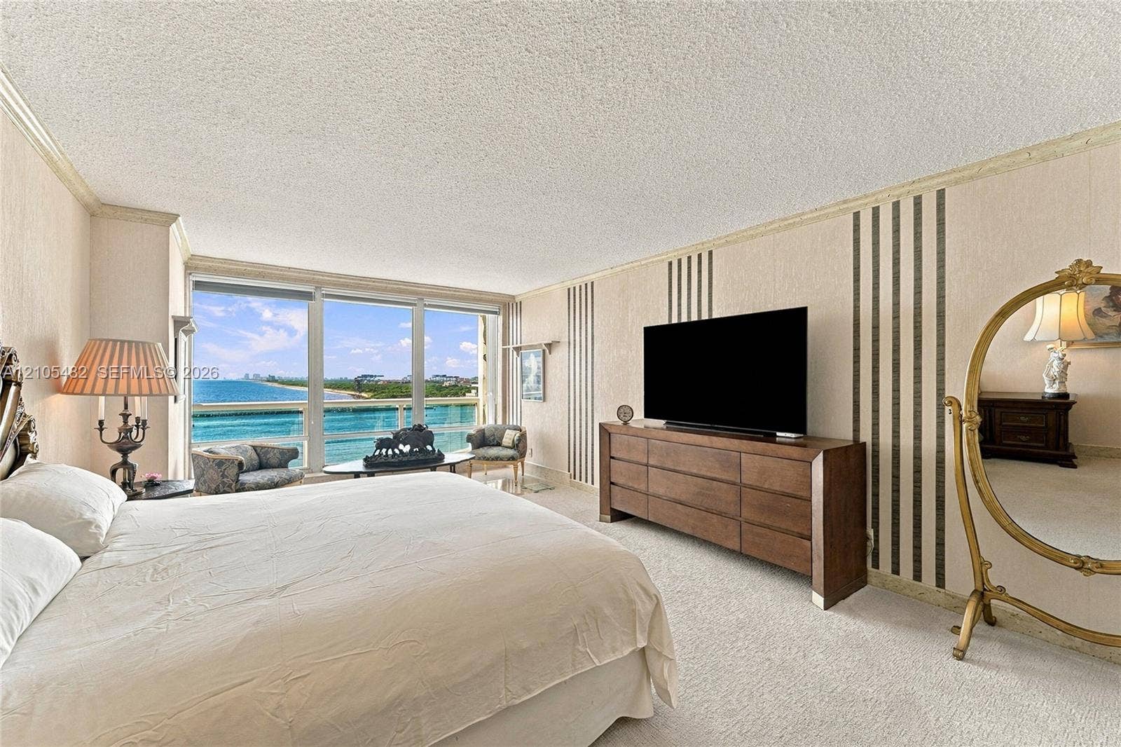 2100 S Ocean Lane, #808, Fort Lauderdale, FL 33316 Floor-to-ceiling windows with coastal horizon exposure and a private balcony featuring a glass railing, complemented by textured wall treatments and wall-integrated paneling