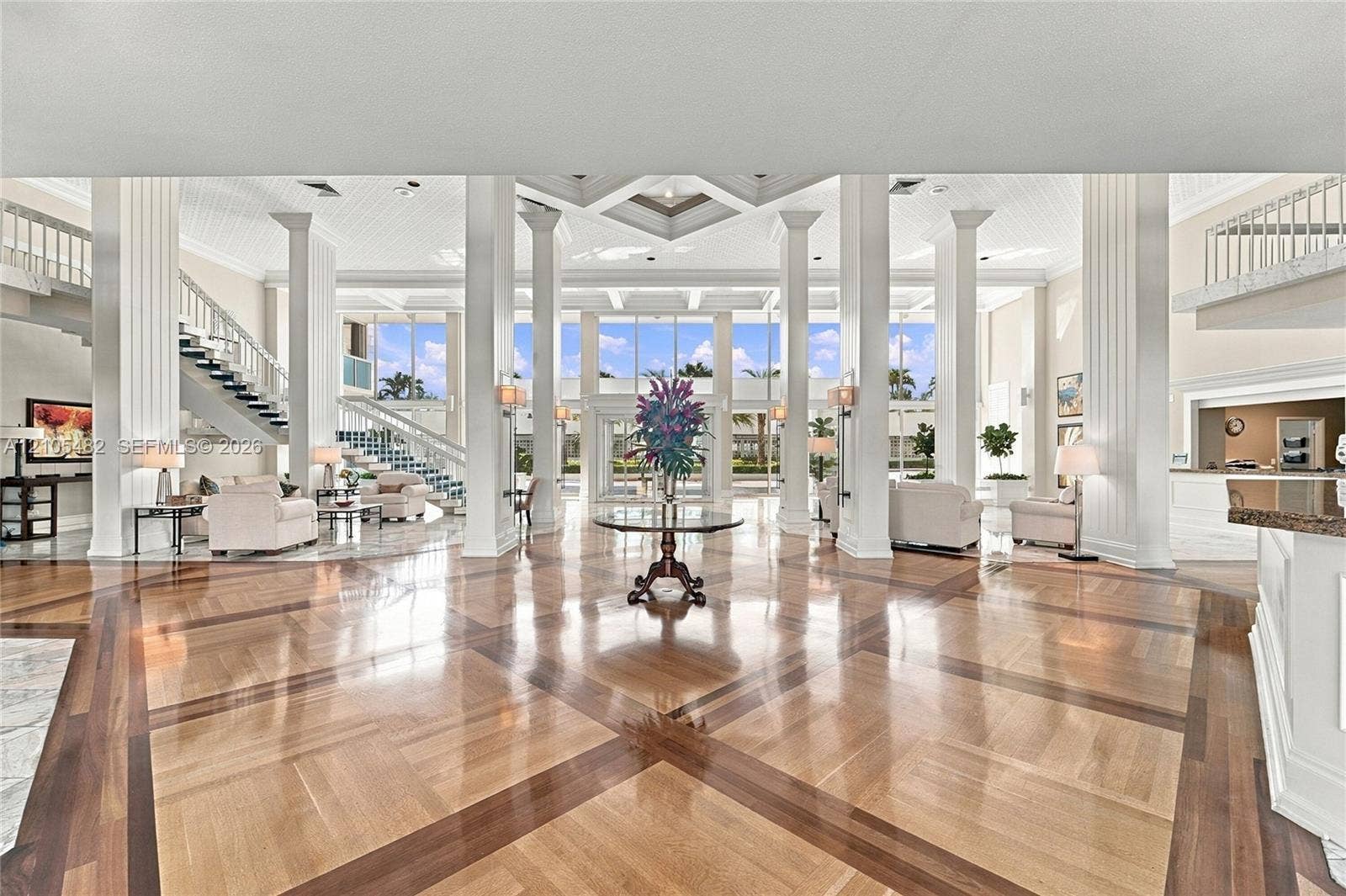 2100 S Ocean Lane, #808, Fort Lauderdale, FL 33316 Grand foyer featuring inlaid wood-finish flooring, soaring coffered ceilings, architectural support columns, and expansive floor-to-ceiling glass windows