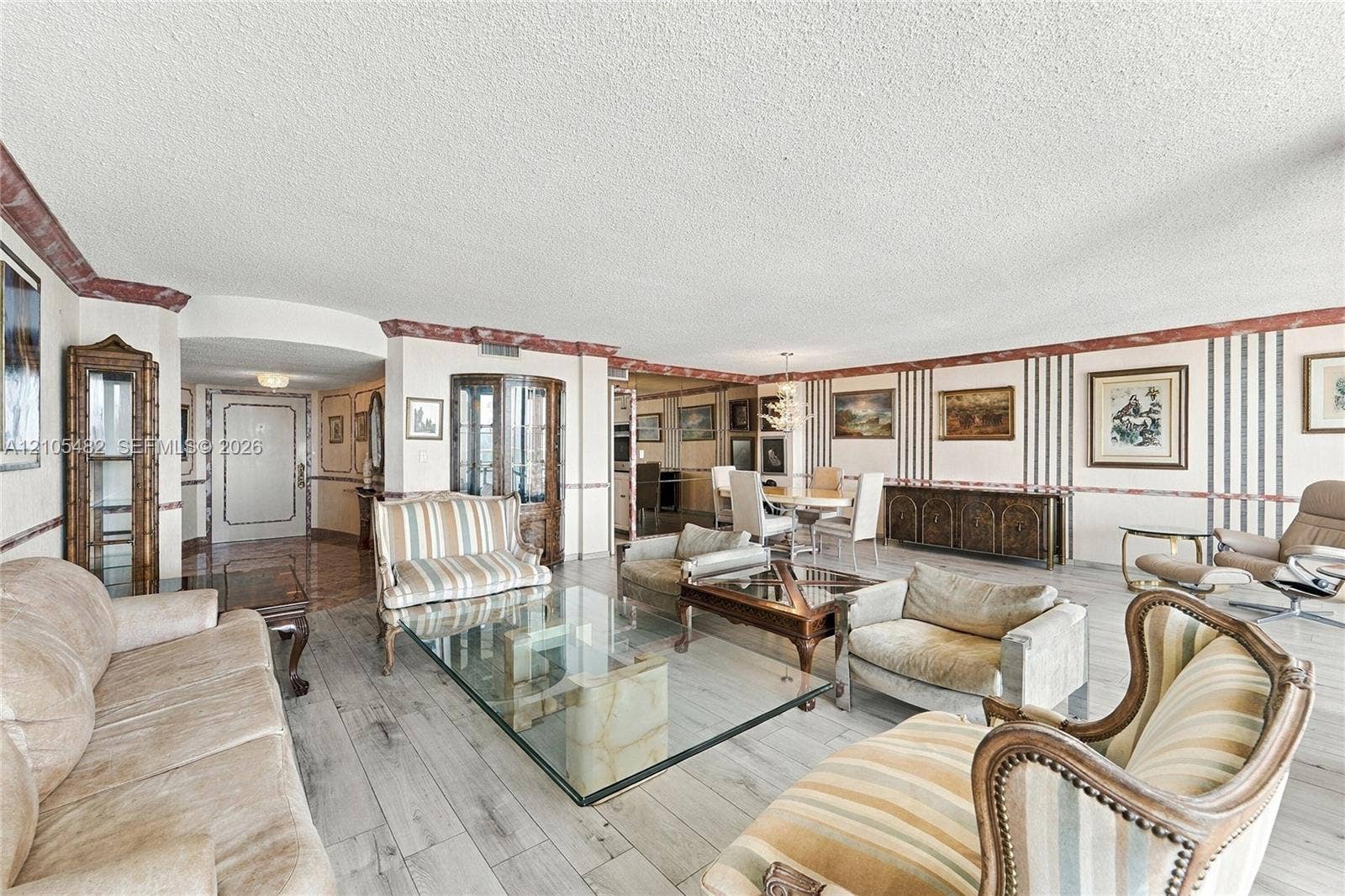 2100 S Ocean Lane, #808, Fort Lauderdale, FL 33316 Open-concept main living area featuring wood-finish flooring, decorative wall trim, built-in cabinetry, and integrated light fixtures