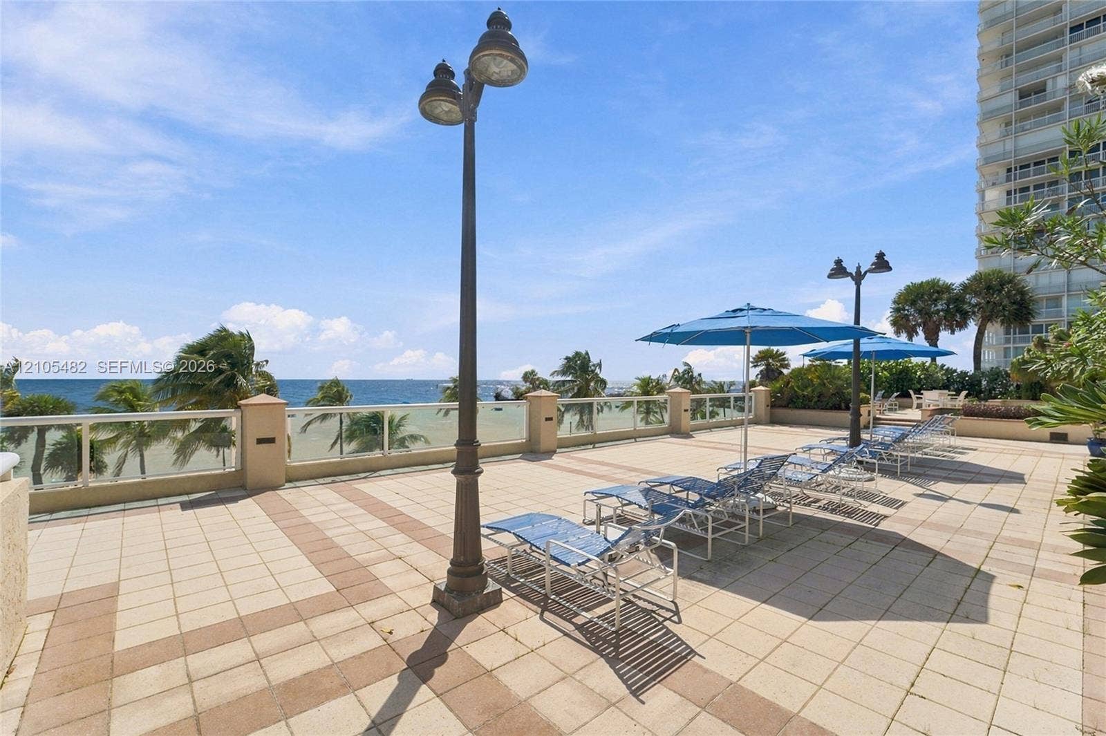2100 S Ocean Lane, #808, Fort Lauderdale, FL 33316 Expansive terrace featuring decorative paver flooring, perimeter glass railing, and tall metal lamp posts