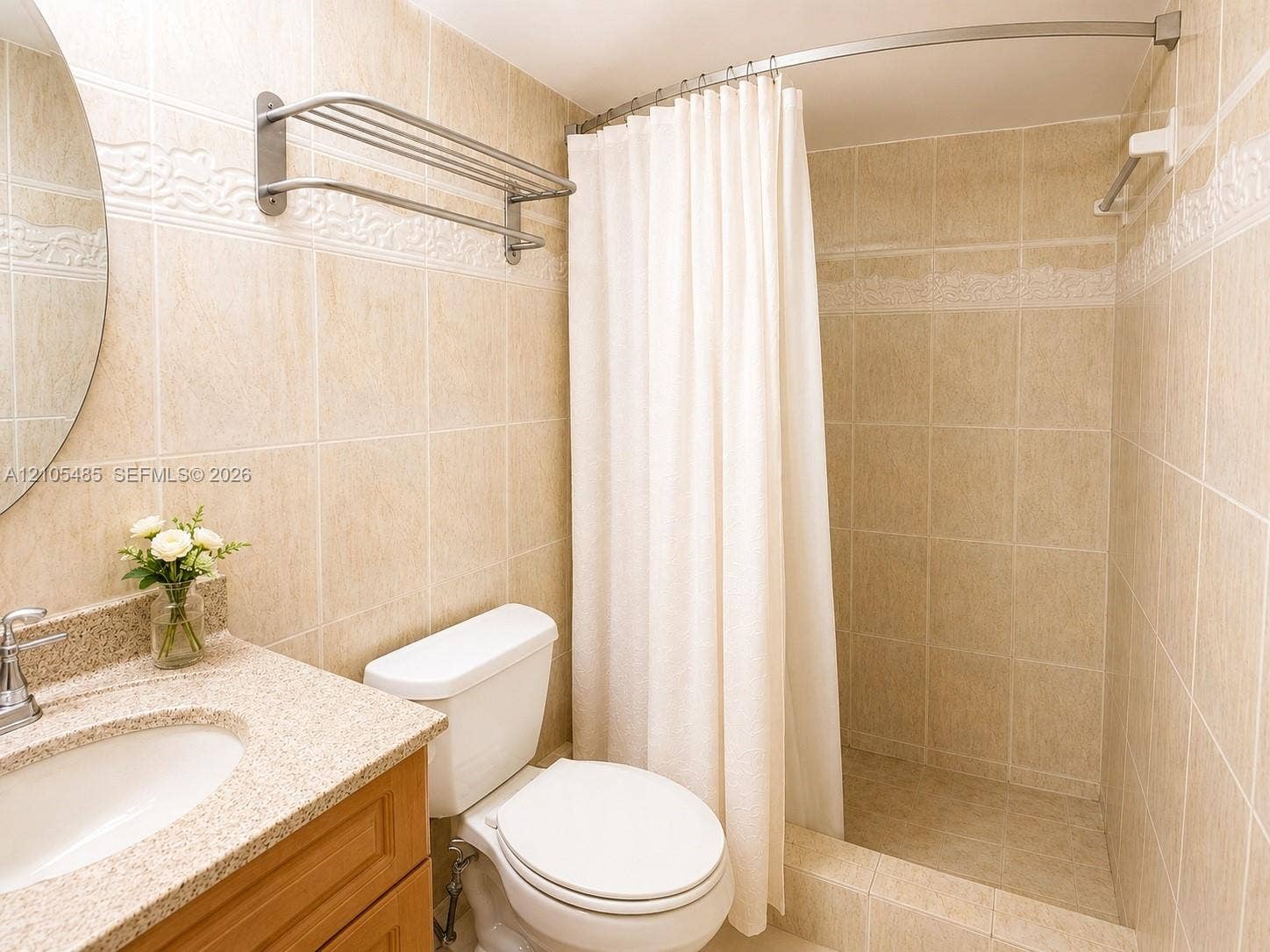 Bathroom featuring a wood-finish vanity with an integrated sink and a speckled countertop