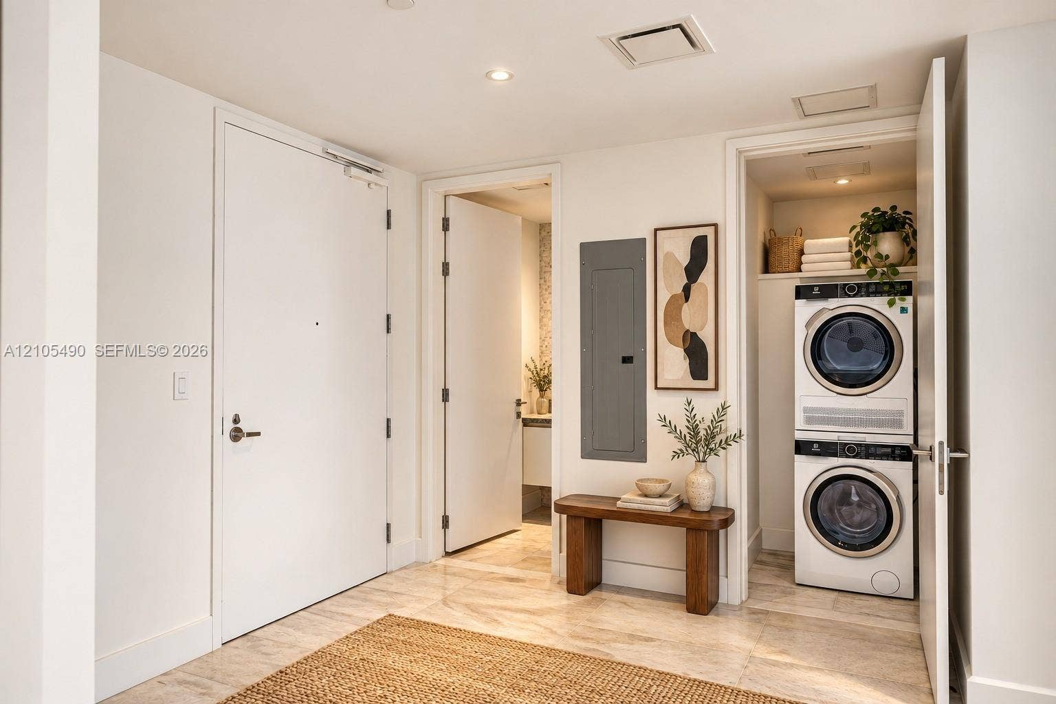 700 NE 26th Terrace, #3603, Miami, FL 33137 Neutral-toned stone flooring and recessed ceiling lighting throughout, featuring a dedicated laundry closet with a stacked washer and dryer, solid-core interior doors, and modern electrical panel