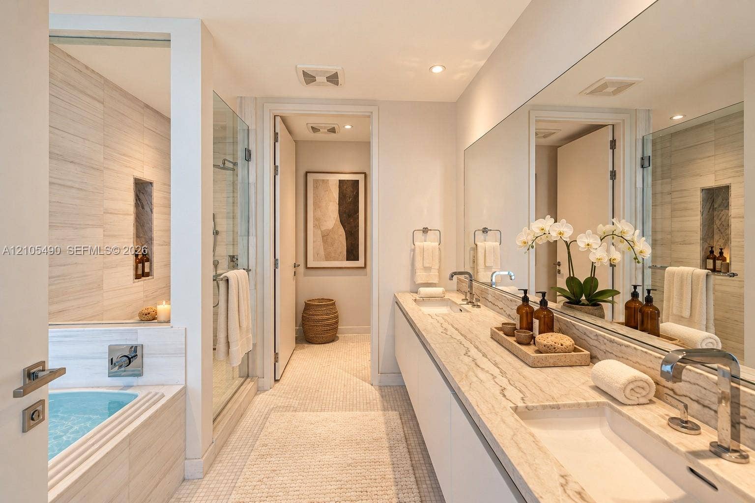 700 NE 26th Terrace, #3603, Miami, FL 33137 Dual-sink vanity with stone countertop, oversized wall-to-wall mirror, glass-enclosed shower, soaking tub with tile surround, and recessed wall niche
