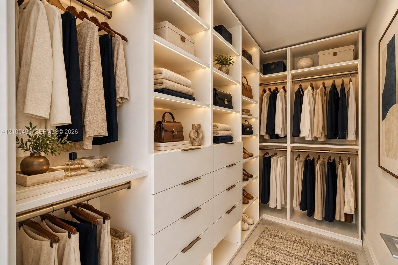 700 NE 26th Terrace, #3603, Miami, FL 33137 Walk-in closet featuring custom white cabinetry, integrated LED shelf lighting, stacked dresser drawers with metallic pulls, and multiple tiered hanging rods