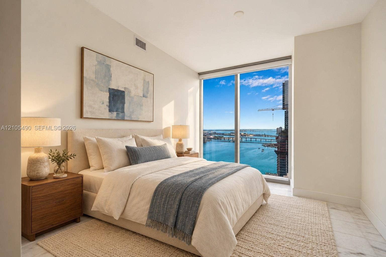 700 NE 26th Terrace, #3603, Miami, FL 33137 Floor-to-ceiling windows featuring panoramic water and city scenery, combined with neutral interior walls and stone-finish flooring