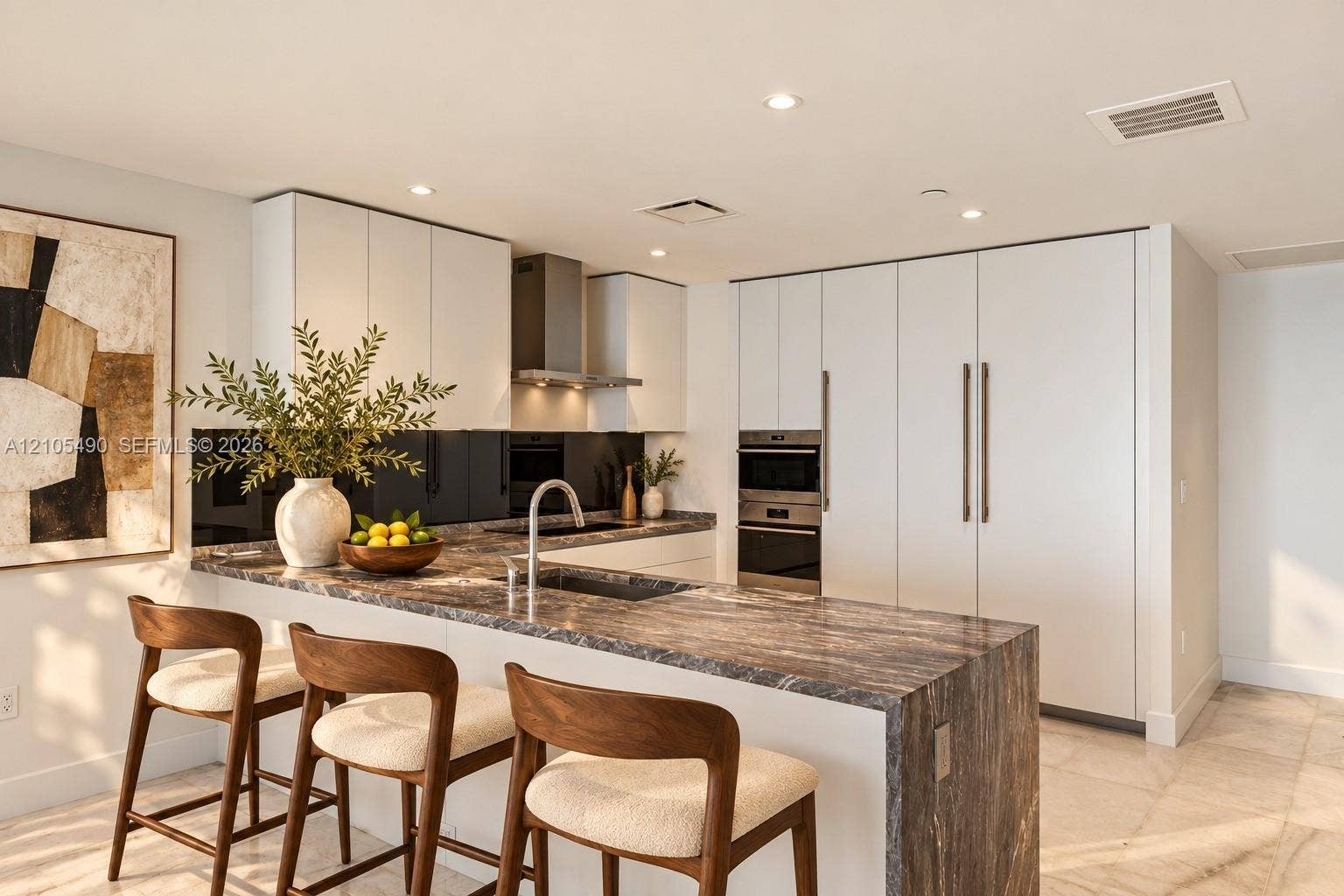 700 NE 26th Terrace, #3603, Miami, FL 33137 Kitchen featuring flat-panel cabinetry, a waterfall-edge stone countertop, integrated stainless steel appliances, a stainless steel range hood, and a dark-toned reflective backsplash