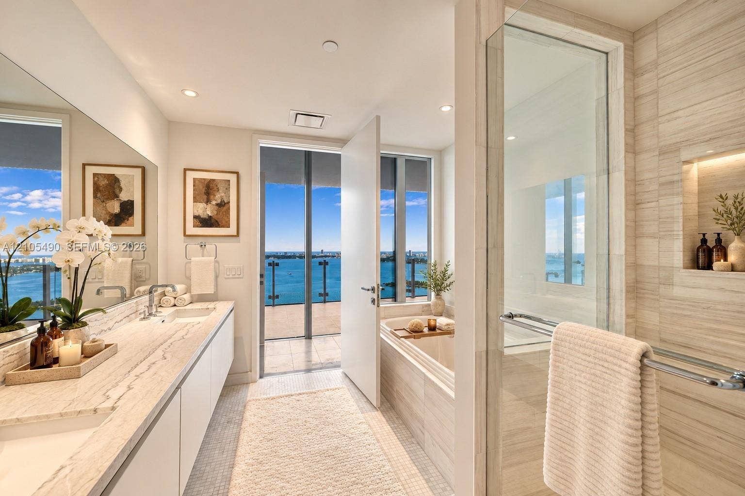 700 NE 26th Terrace, #3603, Miami, FL 33137 Bathroom featuring a dual-sink vanity with stone countertop, soaking tub, glass-enclosed walk-in shower with tiled surround, and integrated recessed shelving