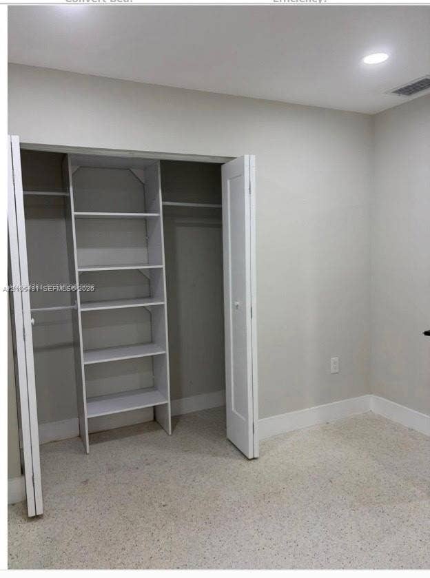 Built-in closet shelving, integrated closet hanging rods, recessed ceiling lighting, and light-toned flooring