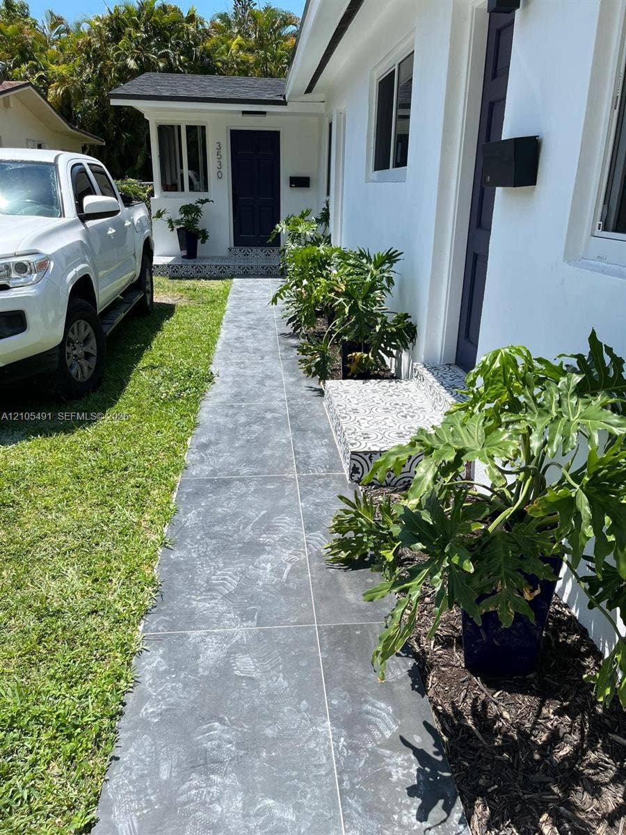 White exterior with dark trim accents, modern black mailbox, and dark front door