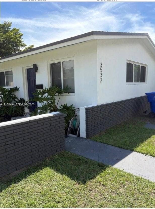 White stucco exterior with a dark blue entry door