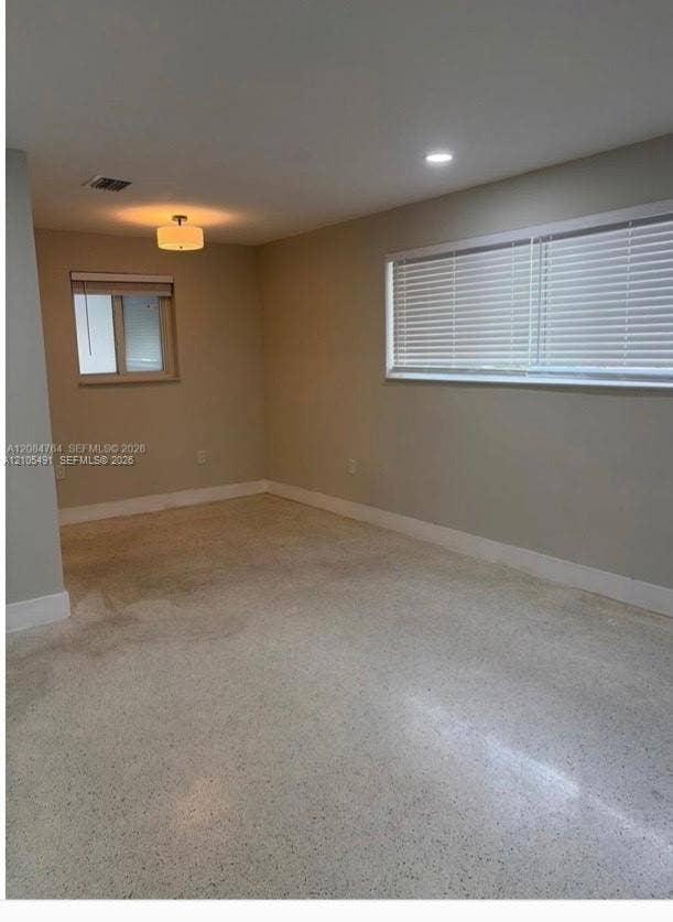Recessed ceiling lighting, a contemporary flush mount fixture, and two windows with horizontal blinds illuminate the space