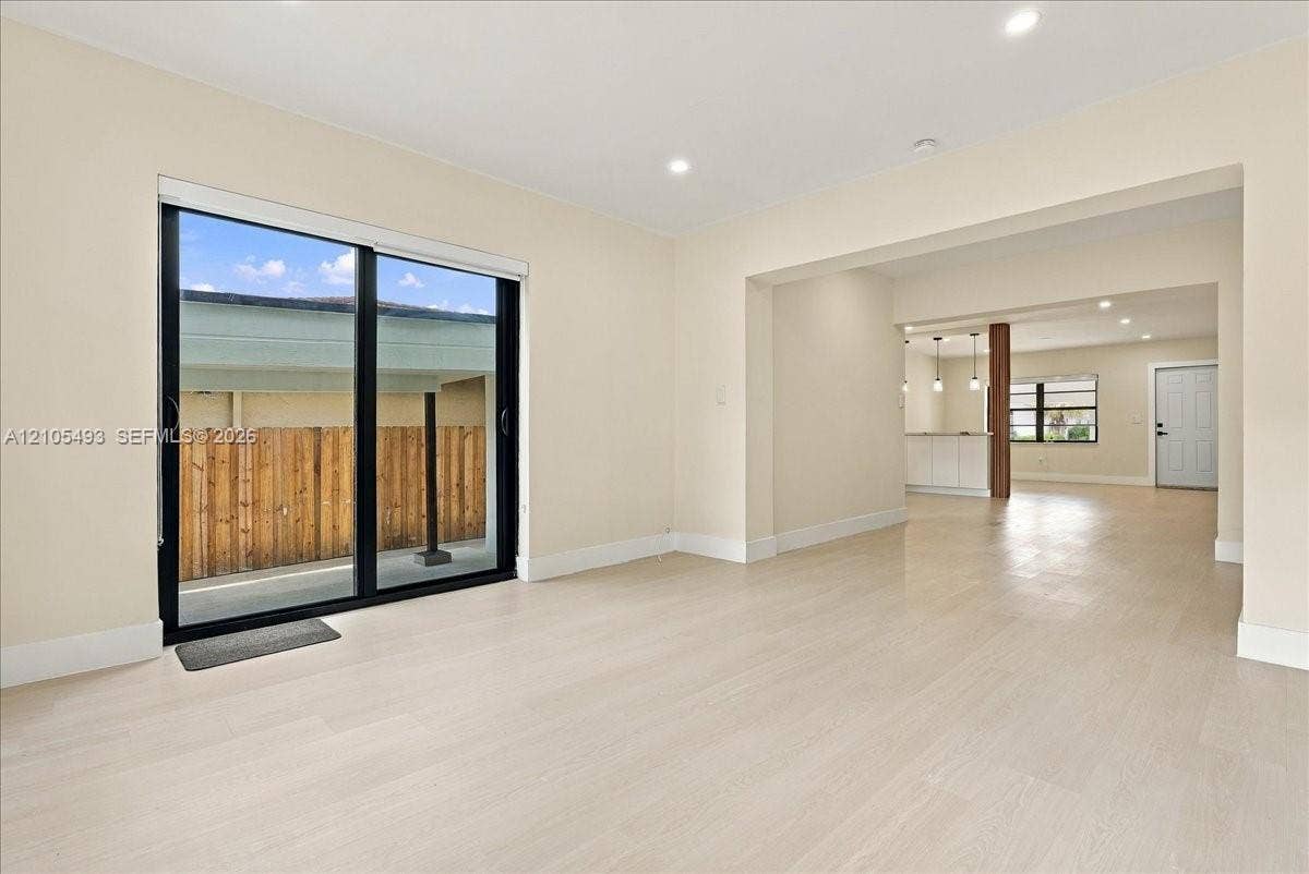 Interior space featuring light-toned wood-finish flooring, recessed lighting, and large glass sliding doors