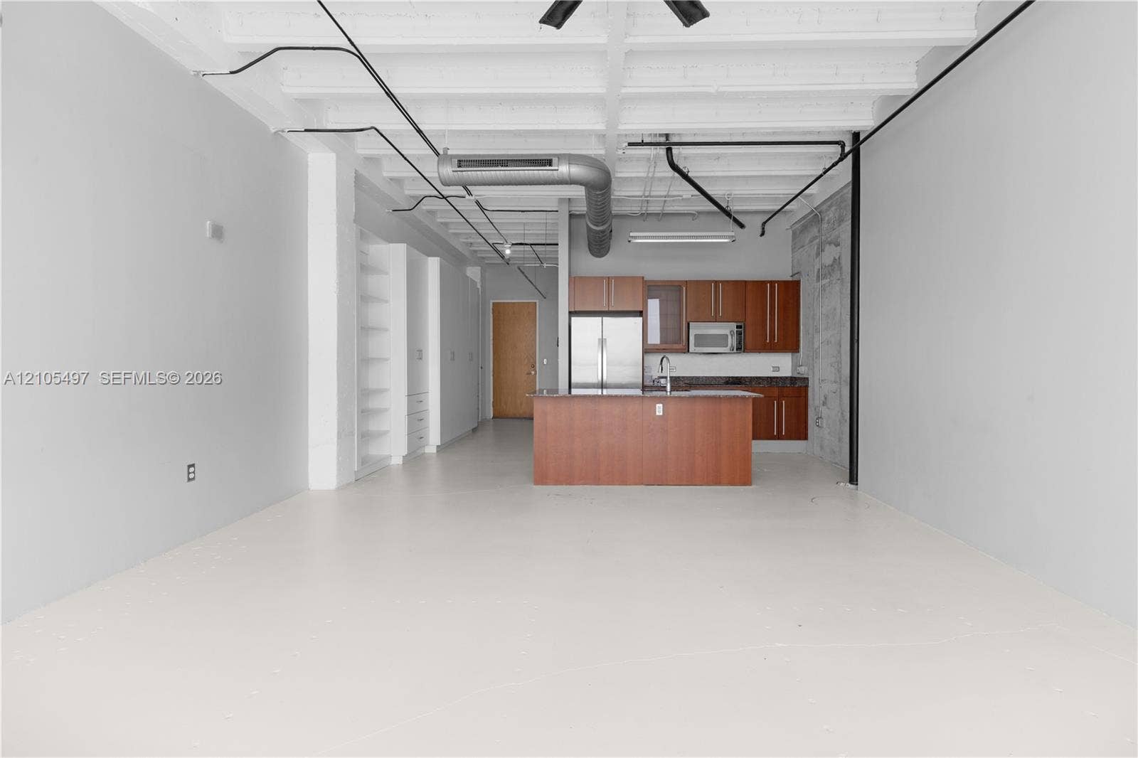Open-concept living area with concrete flooring, exposed ceiling beams, and industrial-style ductwork