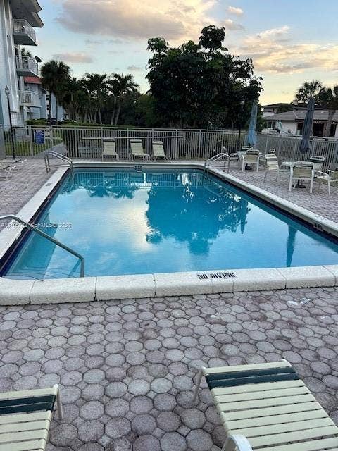 Rectangular swimming pool featuring a perimeter safety fence and paver decking