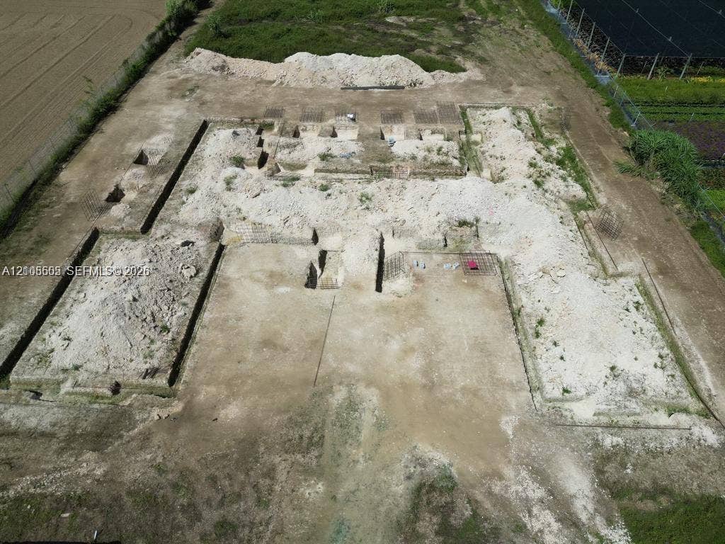 Excavated building footprint with defined foundation trenches and surrounding cleared land