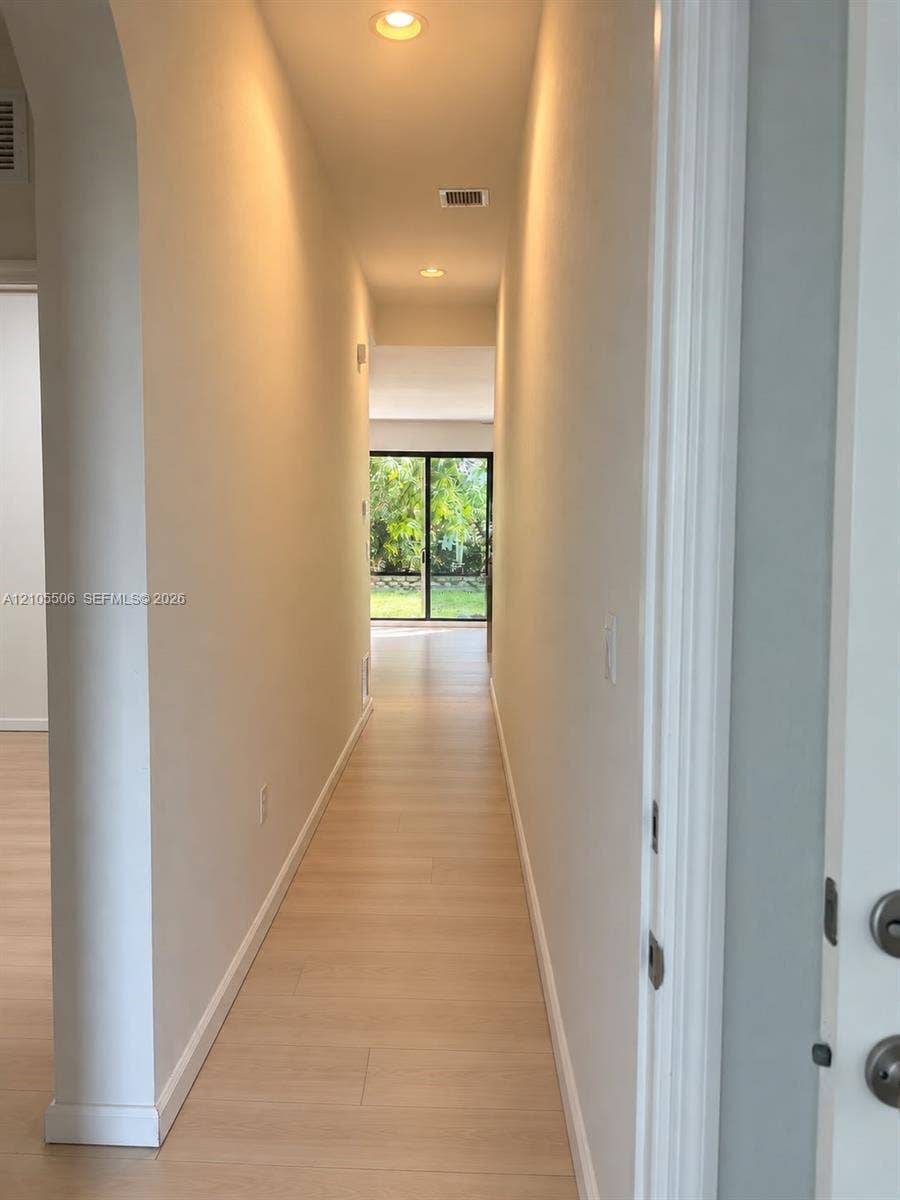 Hallway featuring recessed lighting, light-colored wood-finish flooring, and white baseboards