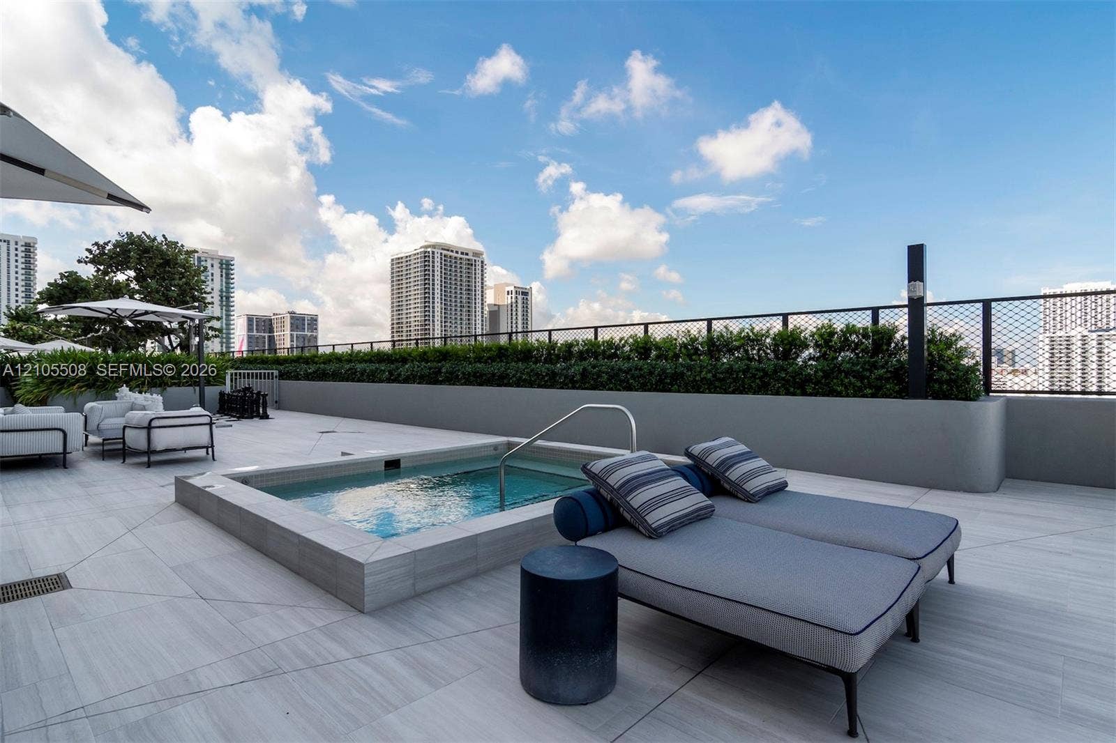 Rooftop patio with a built-in spa, light-toned tile flooring, and perimeter landscaping