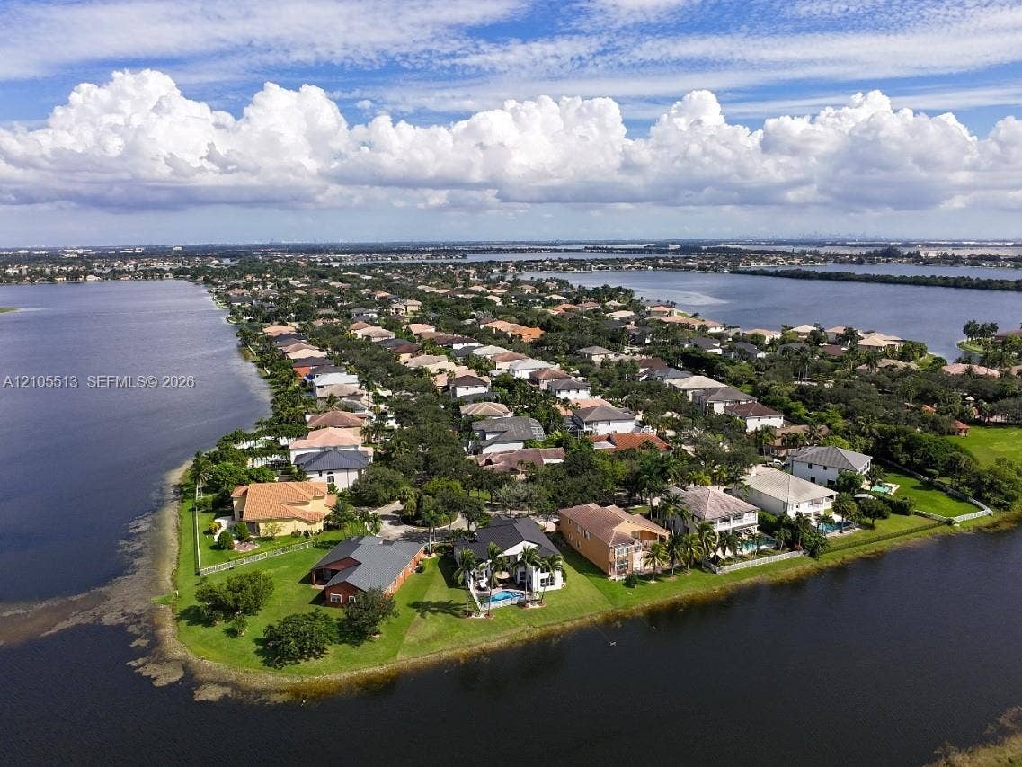 Lakeside community featuring a variety of architectural styles, mature trees, and waterfront properties