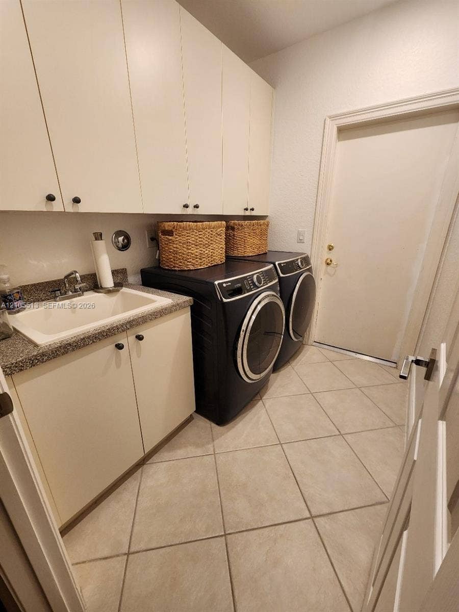 Large laundry room with expansive cabinetry, a built-in utility sink, large storage closet and tile flooring w/brand new GE Profile washer & dryer