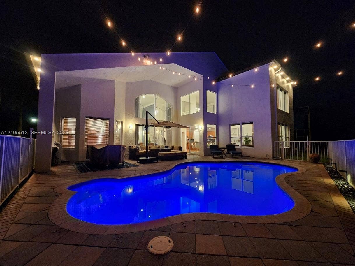 Night view of rear with automated multi-colored LED pool light & low voltage string lighting