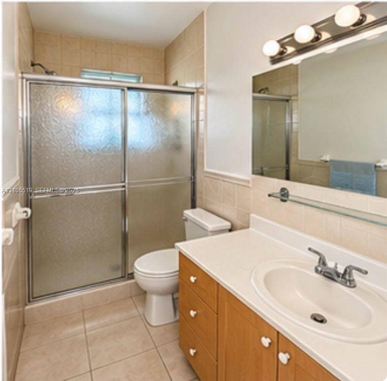 Bathroom featuring a vanity with a light-toned countertop, integrated sink, and wood-finish cabinetry