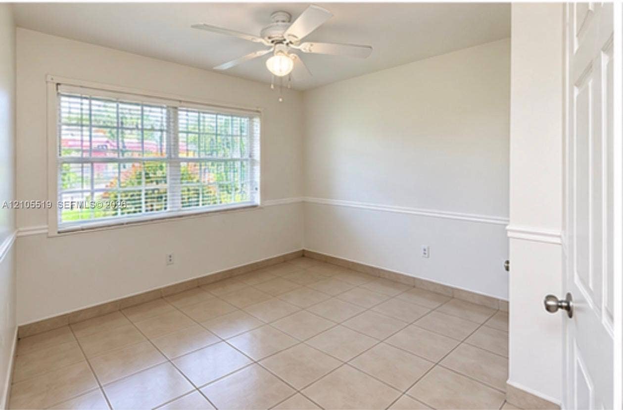 Recessed ceiling fan with light fixture, large window with blinds, tile flooring, and decorative wall trim