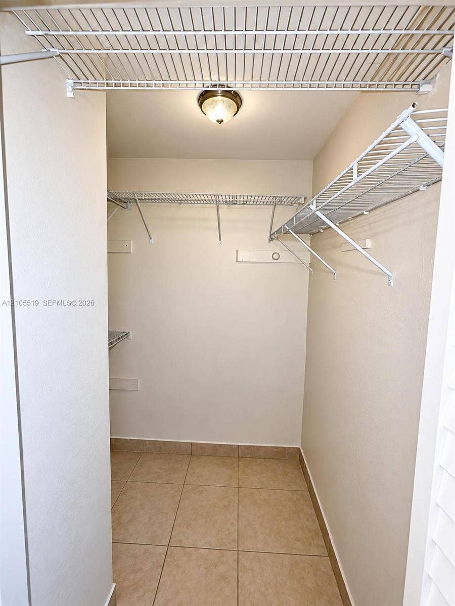 Walk-in closet featuring wire shelving, tile flooring, and a flush mount light fixture