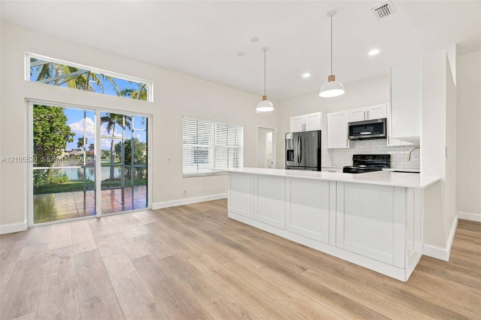649 Willow Bend Road, Weston, Weston, FL 33327 Kitchen featuring a quartz-topped island, white cabinetry, wood-finish flooring, recessed lighting, and sliding glass doors with a transom window