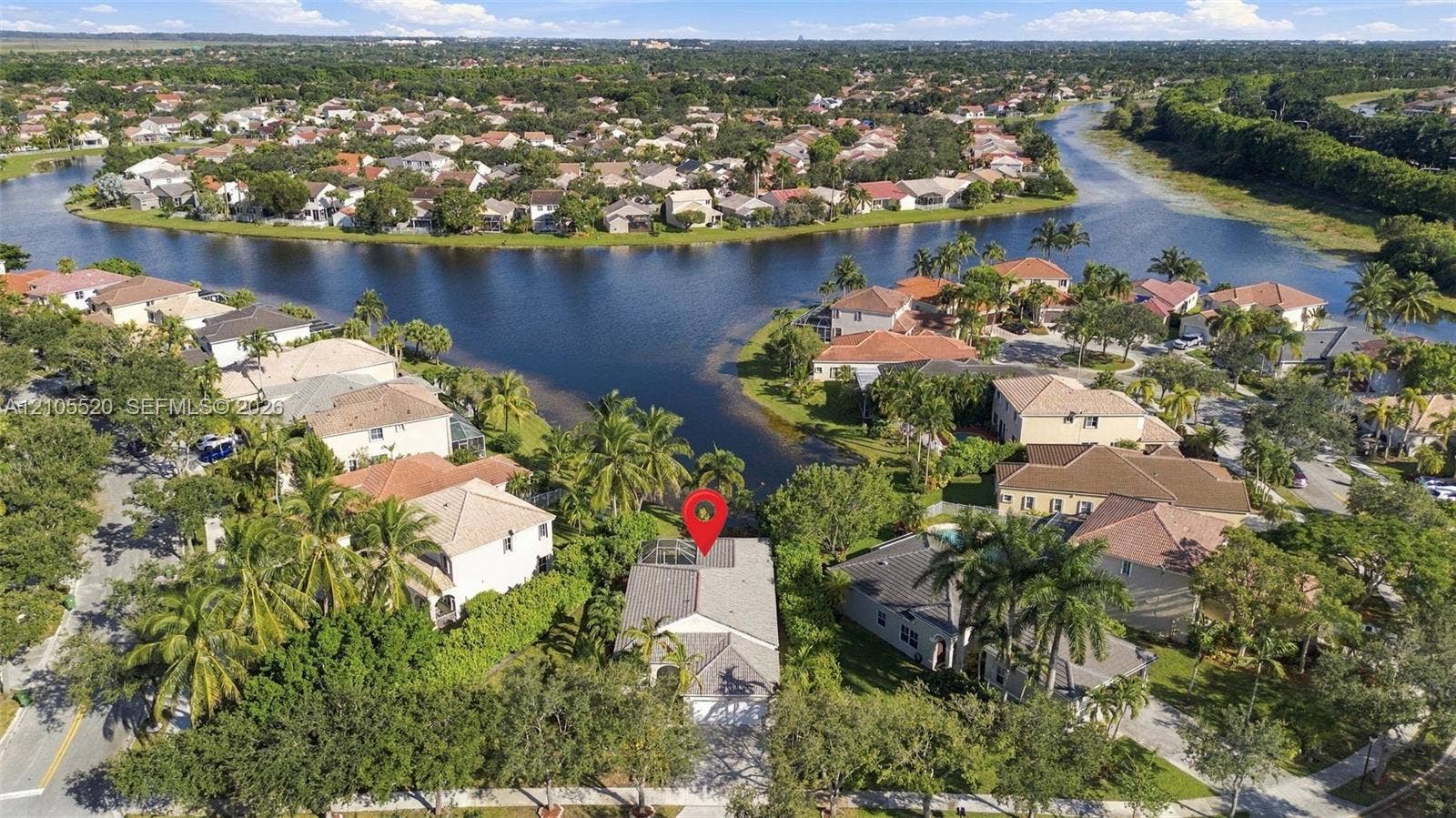 649 Willow Bend Road, Weston, Weston, FL 33327 Aerial perspective of a waterfront residential property featuring an enclosed lanai and established landscaping