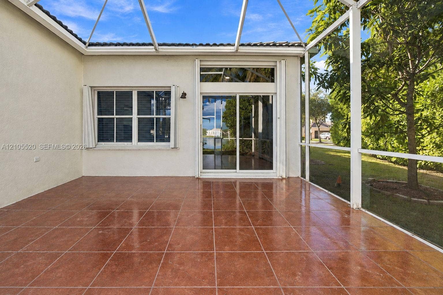 649 Willow Bend Road, Weston, Weston, FL 33327 Screened-in lanai featuring tile flooring, sliding glass doors with a transom window, and white metal framing
