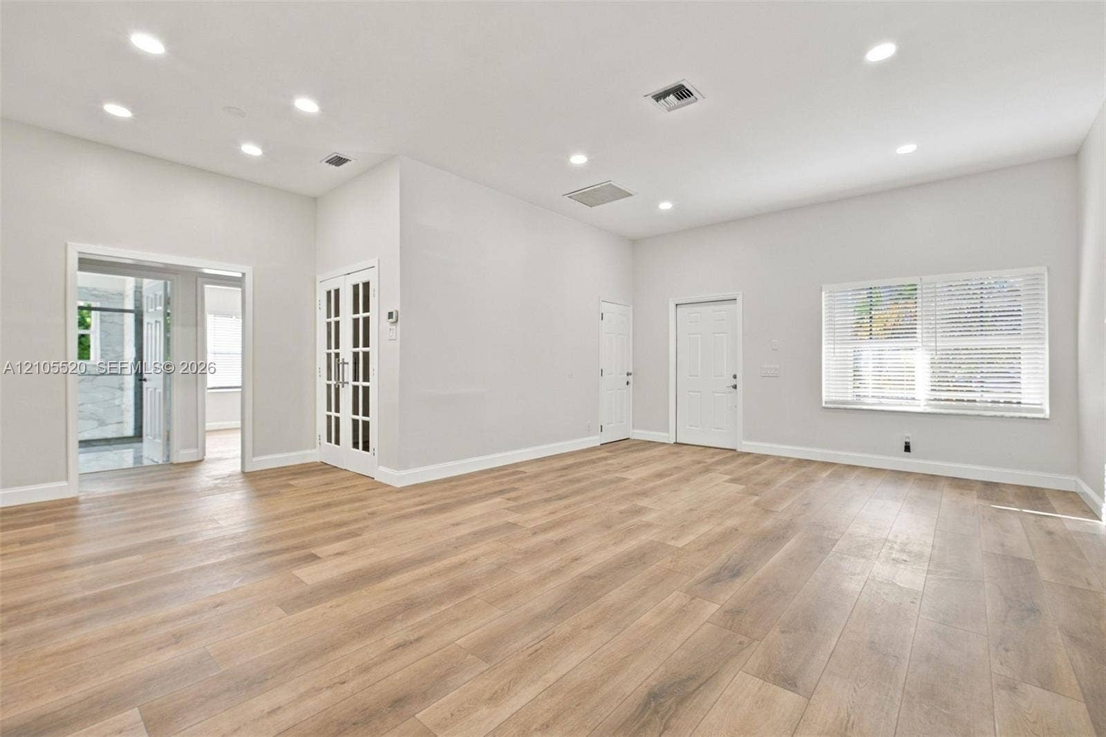 649 Willow Bend Road, Weston, Weston, FL 33327 Open-concept room featuring wood-finish flooring, recessed lighting, white French doors with glass panels, and large windows with horizontal blinds