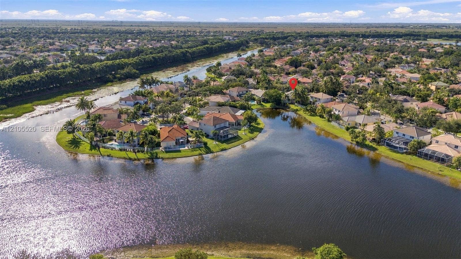 649 Willow Bend Road, Weston, Weston, FL 33327 Aerial perspective of a waterfront property featuring a tile roof, paved driveway, and expansive rear water frontage