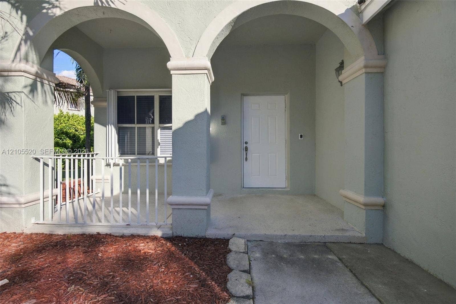 649 Willow Bend Road, Weston, Weston, FL 33327 Covered entry porch featuring arched architectural detailing, stucco pillars, a white paneled front door, and a white metal balustrade