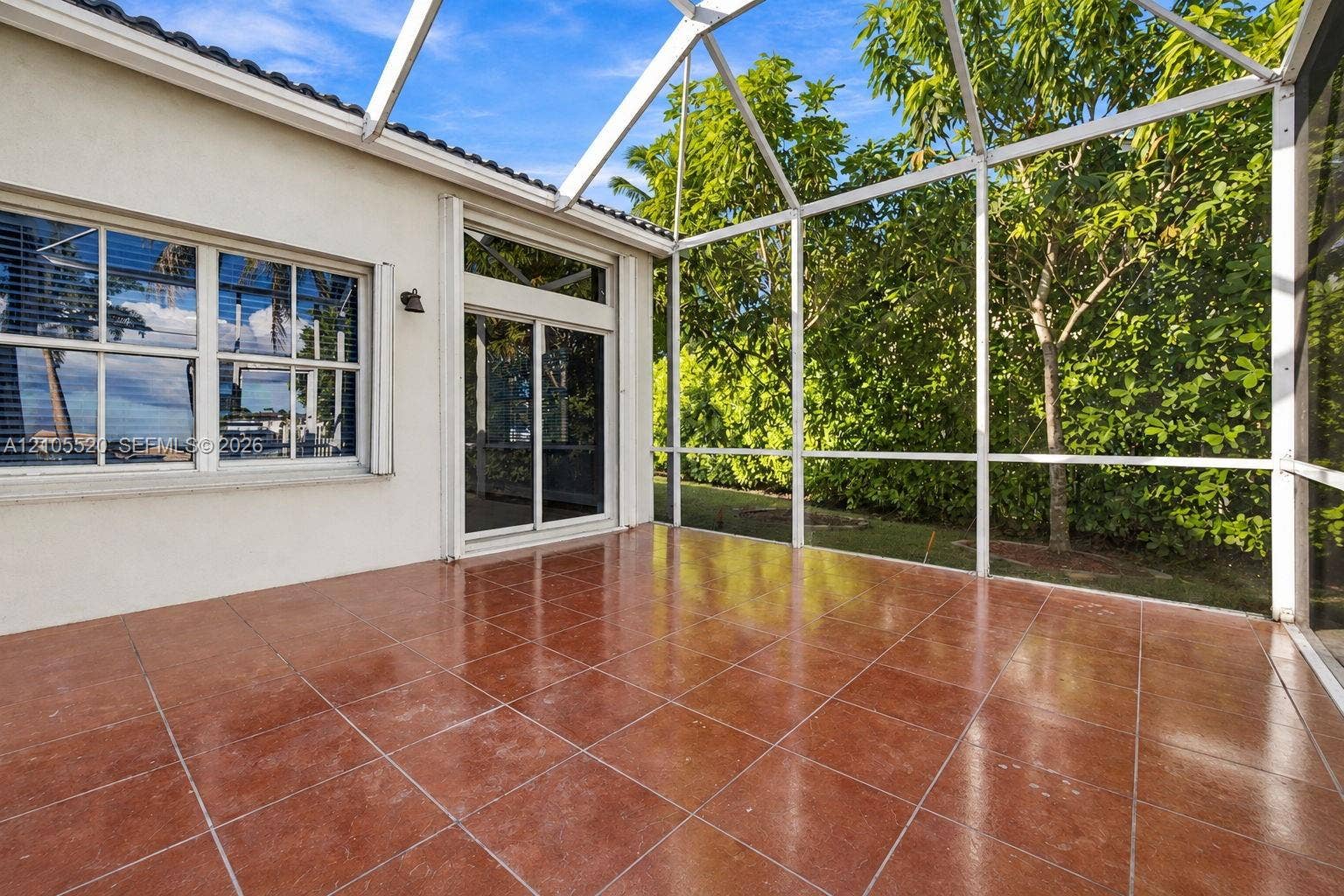 649 Willow Bend Road, Weston, Weston, FL 33327 Screened-in patio featuring tile flooring, aluminum framing, a sliding glass door, and exterior sconce lighting