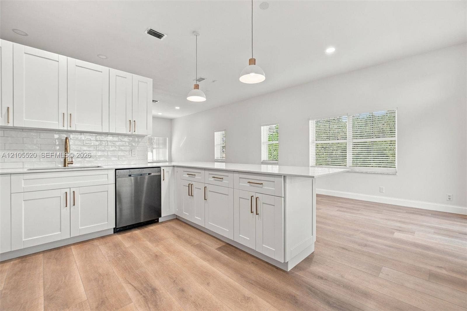 649 Willow Bend Road, Weston, Weston, FL 33327 Kitchen featuring white shaker-style cabinetry, quartz countertops, a stainless steel dishwasher, subway tile backsplash, and wood-finish flooring